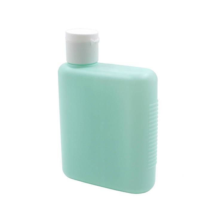 Unlabelled mint green flat plastic cosmetic bottle with a white flip cap on a white background